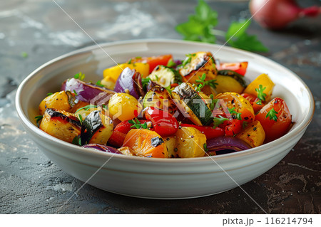 A vibrant bowl of roasted vegetables including zucchini, red onion, bell peppers, and cherry tomatoes, garnished with fresh herbs. A vibrant bowl of roasted vegetables including zucchini, red onion, bell peppers, and cherry tomatoes, garnished with fresh herbs. 116214794