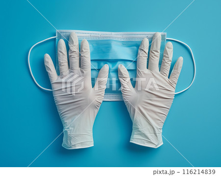 Blue medical face mask and white gloves on blue background, symbolizing healthcare, hygiene, and protection in the medical field. Blue medical face mask and white gloves on blue background, symbolizing healthcare, hygiene, and protection in the medical field. 116214839