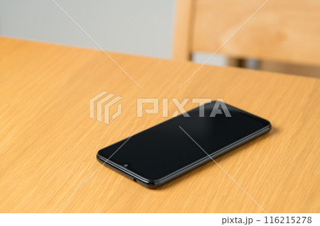 机の上に置かれたスマホ 116215278