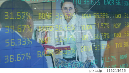 Image of trading board over diverse designers discussing design on laptop in office 116215626