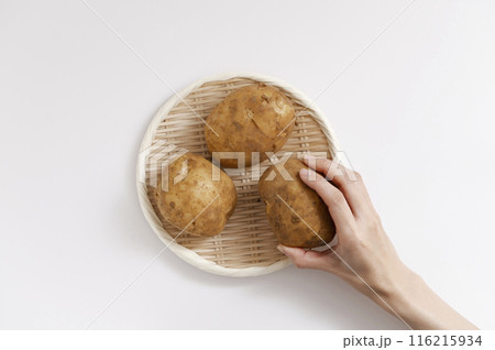 白背景上にあるジャガイモを取る女性 116215934