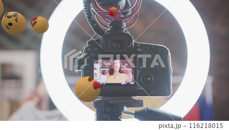 Image of emoji icons over female vlogger on camera viewer recording vlog at home Image of emoji icons over female vlogger on camera viewer recording vlog at home 116218015