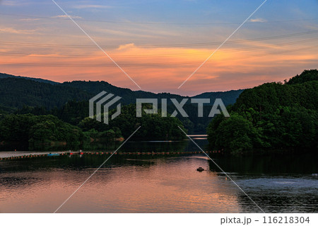 2024年夏布目ダム夕景　日没後黄金色に染まる空とダム湖の水面 116218304