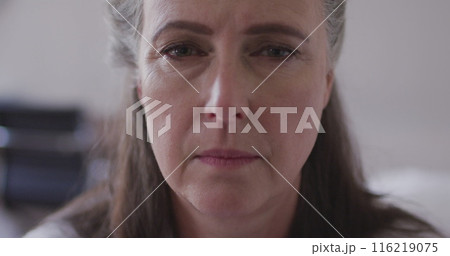 Caucasian mature woman with long brown hair and gray streaks is looking forward Caucasian mature woman with long brown hair and gray streaks is looking forward 116219075