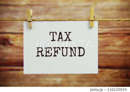 Tax Refund text on paper card hanging on the wall with Clothespins 116220934