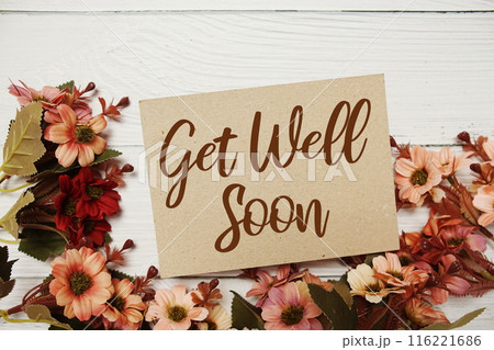 Get well Soon typography text with flower decorated on wooden background Get well Soon typography text with flower decorated on wooden background 116221686