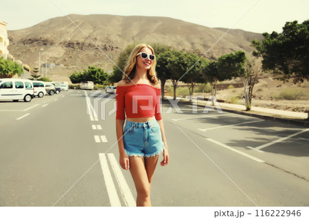 Happy beautiful caucasian young woman standing on the road on a summer day 116222946