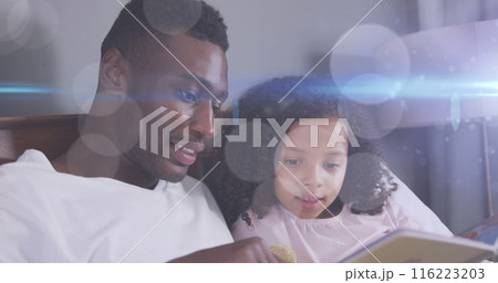 Image of light spots over happy african american father reading book with daughter 116223203
