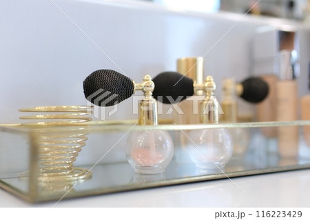 Drops of rose water fall into old fashioned reagent bottle in front of two pink roses on white background Abstract body care cosmetics with rose water formulation concept 116223429