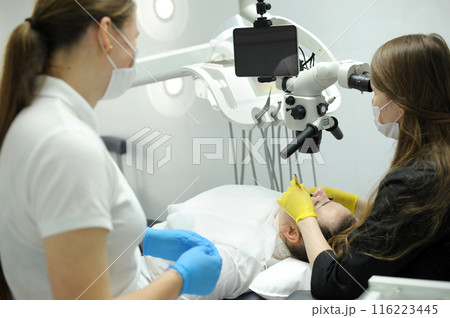 Dentistry microscope dentist working with dental microscope in modern stomatology clinic. microscope for root canal treatment. Stomatologist performs a surgical operation. Cosmetic dentistry 116223445
