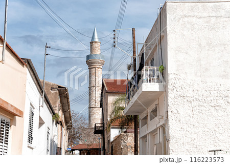 Tall minaret of Djami Kebir mosque is standing over traditional houses in Paphos, Cyprus 116223573