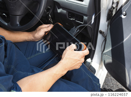 車の診断機を使う自動車整備士さん 116224037