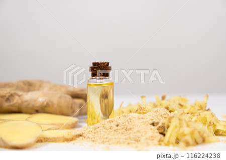Natural ginger oil in glass bottle among ginger roots 116224238