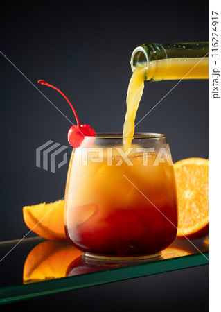 Tequila Sunrise alcoholic cocktail on a dark background. 116224917