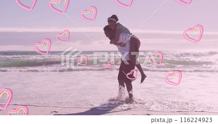 Image of pink hearts over happy african american couple piggybacking on beach Image of pink hearts over happy african american couple piggybacking on beach 116224923