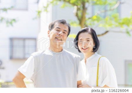 アンションの前で寄り添うシニア夫婦 116226004