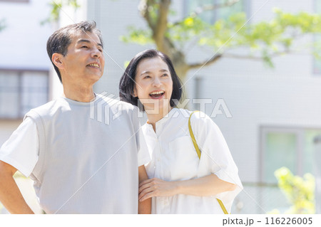 アンションの前で寄り添うシニア夫婦 116226005