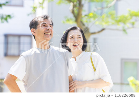 アンションの前で寄り添うシニア夫婦 アンションの前で寄り添うシニア夫婦 116226009