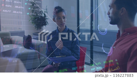Image of graphs and trading boards over diverse coworkers discussing in office 116227883