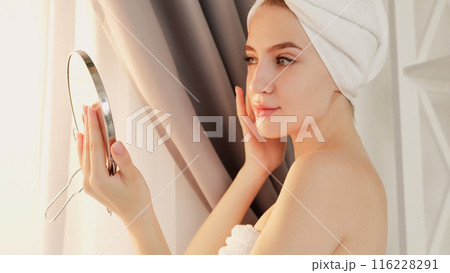 Moisturizing skincare. Daily routine. Natural beauty. Smooth skin treatment. Young smiling woman with flawless face admiring look holding mirror. 116228291