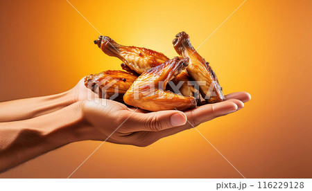 Hands Holding Grilled Chicken Wings on a Yellow-Orange Background - Generative Ai 116229128
