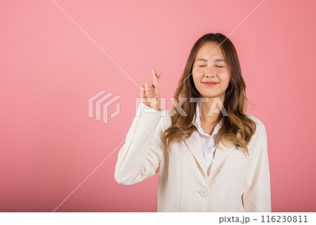 Asian happy portrait beautiful cute young business woman smile have superstition her holding fingers crossed for good luck gesture studio shot isolated on pink background, Thai female with copy space Asian happy portrait beautiful cute young business woman smile have superstition her holding fingers crossed for good luck gesture studio shot isolated on pink background, Thai female with copy space 116230811