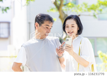 一緒にスマホを見るミドル夫婦 116231770