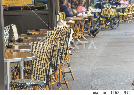 Traditional terrace in street cafe with tables and chairs in Paris, France Traditional terrace in street cafe with tables and chairs in Paris, France 116231996