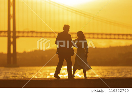 Couple Dancing at Sunset by a Bridge 116232790