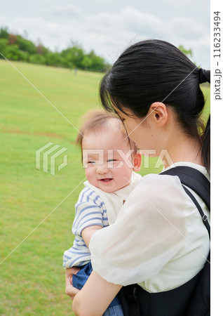 公園で赤ちゃんを抱くお母さん 公園で赤ちゃんを抱くお母さん 116233494