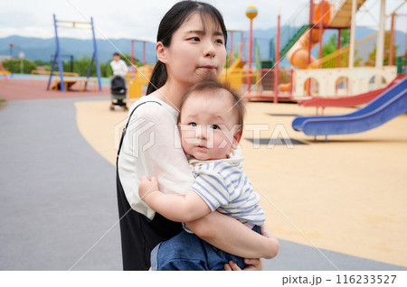 公園で赤ちゃんを抱くお母さん 公園で赤ちゃんを抱くお母さん 116233527