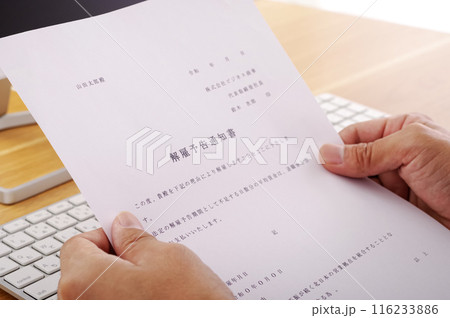 解雇予告の通知書を見つめる男性 解雇予告の通知書を見つめる男性 116233886