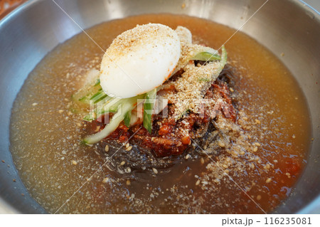 Naengmyeon is a unique Korean noodle dish made with cold broth topped with seasonings and toppings Naengmyeon is a unique Korean noodle dish made with cold broth topped with seasonings and toppings 116235081
