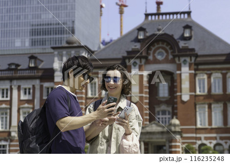インバウンド　東京駅の前でスマホで検索する外国人旅行者カップル 116235248