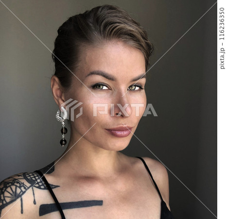 Portrait of a young woman in unusual massive earrings 116236350