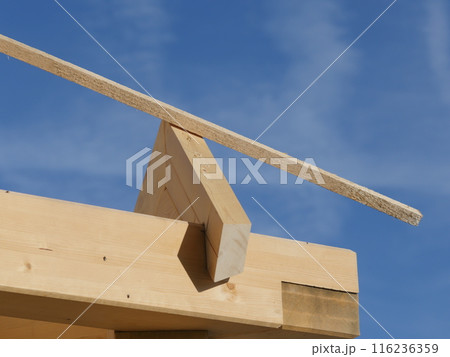 A wooden beam is leaning on a roof A wooden beam is leaning on a roof 116236359