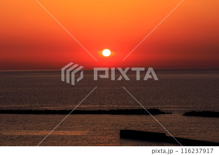 春の新潟の海に沈む丸い太陽と美しい真っ赤な夕焼け 116237917