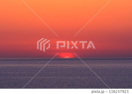 新潟の春の海に沈みそうな太陽と真っ赤な夕焼け 116237923