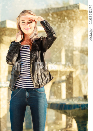 woman casual style posing against city fountain woman casual style posing against city fountain 116238174