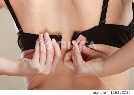 Woman dressing up her bra rear view 116238235