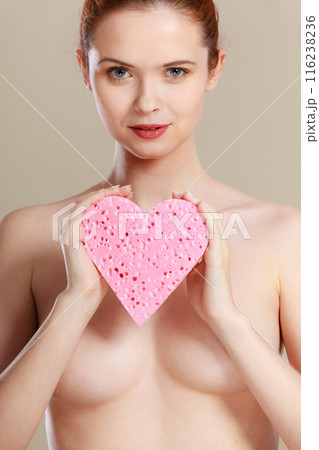 Naked woman holding pink heart sponge in hands. 116238236