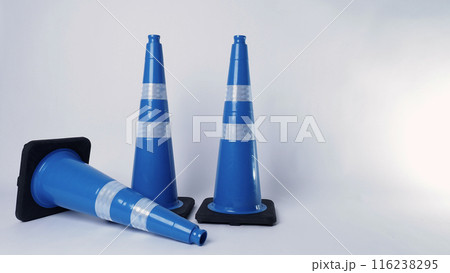 Road traffic safety equipment. Realistic blue traffic cones and yellow safety helmet isolated on white background. Roadside tools for road work or unpredicted automotive accident. Safety first concept 116238295