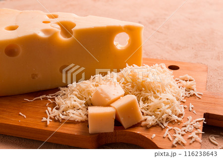 Grated cheese, Maasdam, on a cutting board, grater and cheese knife, close-up, no people, 116238643