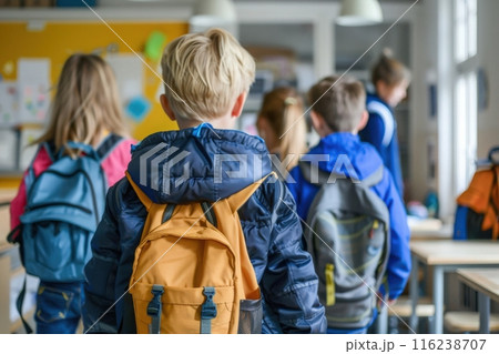 A group of students walk into a classroom with their backpacks, ready to begin a new school year. 116238707