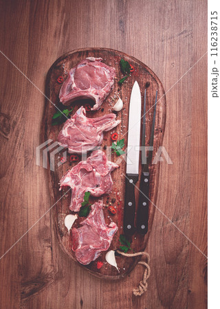 raw calf meat, meat on the bone, meat for barbecue, cutting board, with spices and herbs, top view, 116238715