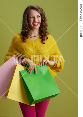 happy modern woman in yellow sweater on green background 116239288