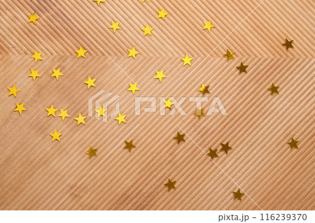 Abstract New Year and Christmas corrugated background in beige color with gold stars. 116239370