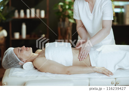 massage therapist in massage cabinet massaging clients belly 116239427