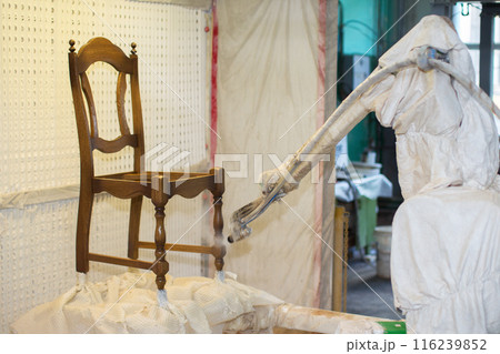 Furniture factory. Robot machine lacquer chair.Making chairs in the factory 116239852