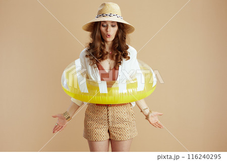 surprised housewife in blouse and shorts on beige surprised housewife in blouse and shorts on beige 116240295